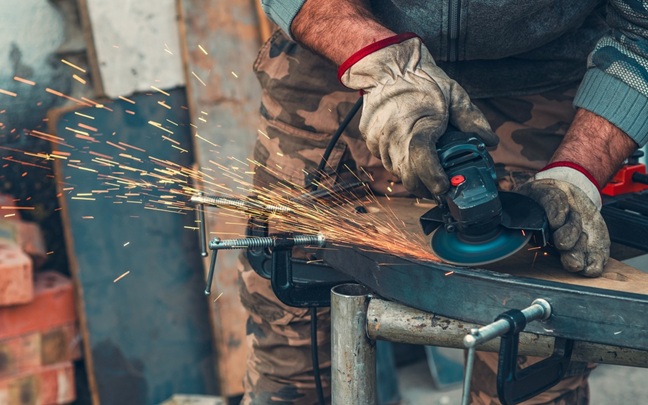 Close-up,Of,Manual,Worker,Operating,Grinder,With,Intense,Sparks,,Highlighting