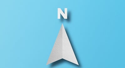 White,Paper,Cut,In,North,Arrow,Shape,Set,On,Light