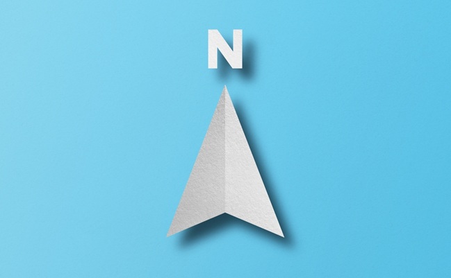 White,Paper,Cut,In,North,Arrow,Shape,Set,On,Light
