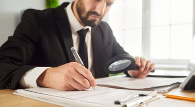 Business,Audit,,Scrutiny,Analysis,By,Businessman,Reading,Office,Documents,With