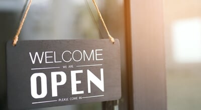 Black,Open,Sign,With,Welcome,Text,Hanging,On,Glass,Door