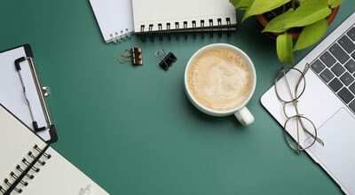 Office,Workplace.,Laptop,,Coffee,And,Stationery,On,Green,Desk,,Flat