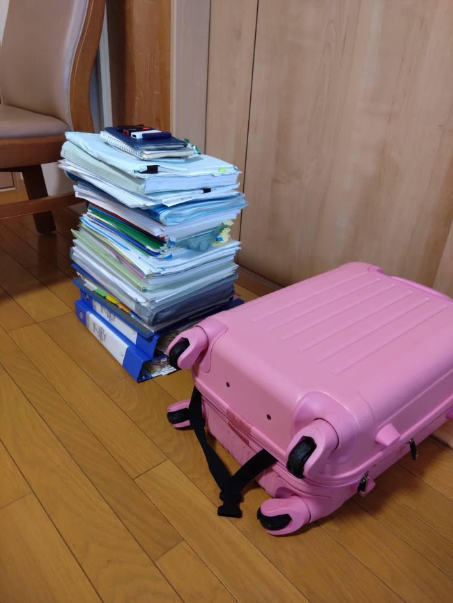 取材中に被害側に提供してもらった偽造関係書類の一部と重さで壊れてしまったスーツケース