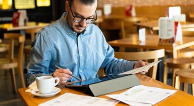 Man,Using,A,Digital,Tablet,With,A,Stylus,,Organizing,Paper