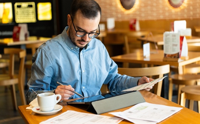 Man,Using,A,Digital,Tablet,With,A,Stylus,,Organizing,Paper