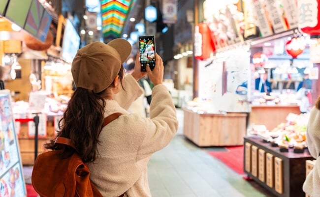 Young,Female,Tourist,Taking,A,Photo,Of,The,Popular,Nishiki