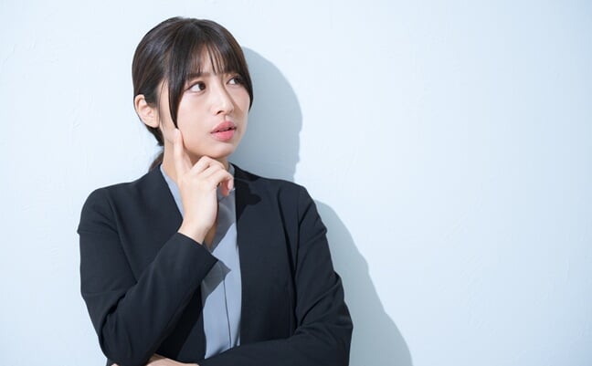 Young,Japanese,Woman,In,Suit,With,Hand,On,Chin,Thinking