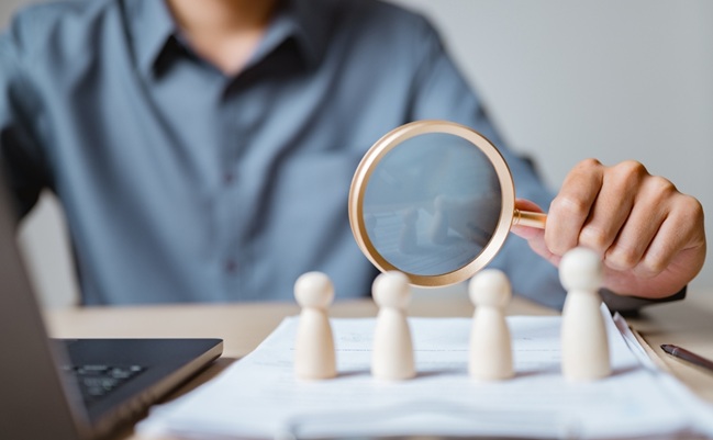 Close-up,Of,A,Person,Using,Magnifying,Glass,To,Examine,Wooden