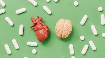 Heart,Versus,Brain,Concept,With,Medical,Pills,On,Green,Background.