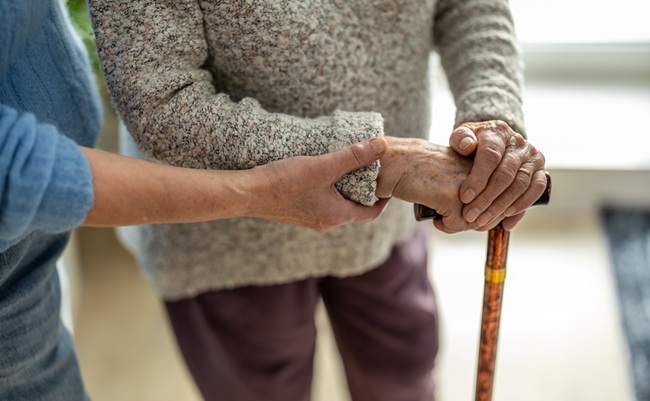 Senior,Woman,With,Walking,Stick,Getting,Support,From,Nurse,,Close-up