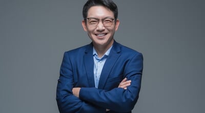 Confident,Smiling,Asian,Businessman,Wearing,Glasses,And,Blue,Suit,With